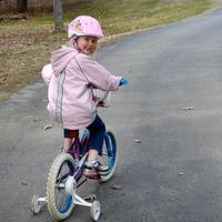 Kira riding bicycle up the driveway